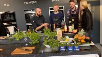 Four people cooking in a modern kitchen.