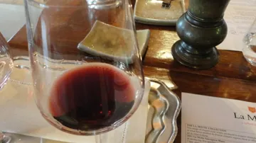 Wine glass with red wine on table.