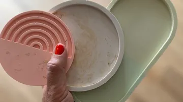 Hand holding multicolored decorative plates.
