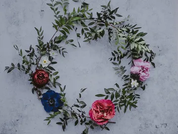 Blütenkranz aus bunten Blumen auf grauem Untergrund.