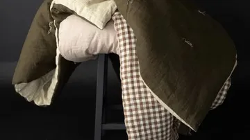 Gesteppte Decken, die über einem Hocker drapiert sind.