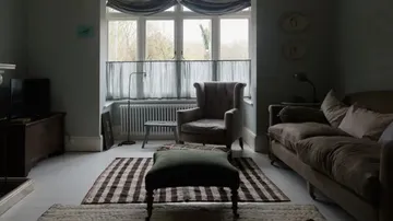 Gemütliches Wohnzimmer mit Sofas und Sessel in der Nähe des Fensters.