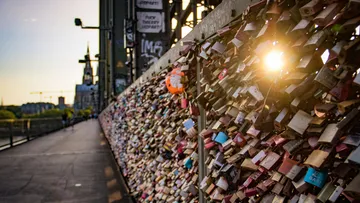 Bridge with colorful love locks and sunset