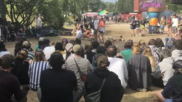 People attending outdoor performance in park.