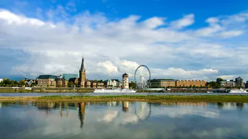 Cityscape with ferris wheel and river reflection