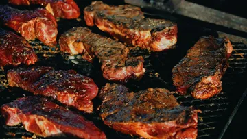 Brutzelnde Steaks auf einem Barbecue-Grill.