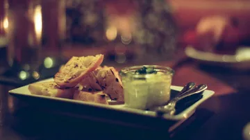 Bread slices with dip in a dim setting.