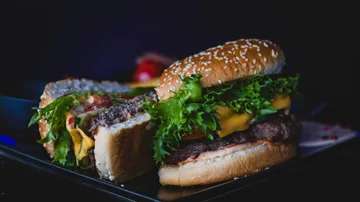 Cheeseburger with lettuce and tomato on plate.