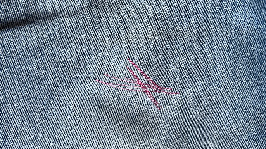 Blue denim fabric with red stitched patch.