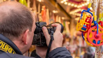 Person, die farbenfrohe Spielzeuge auf dem Markt fotografiert.