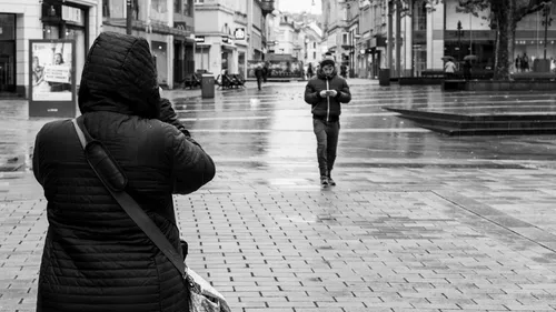 Two people in jackets on empty street.