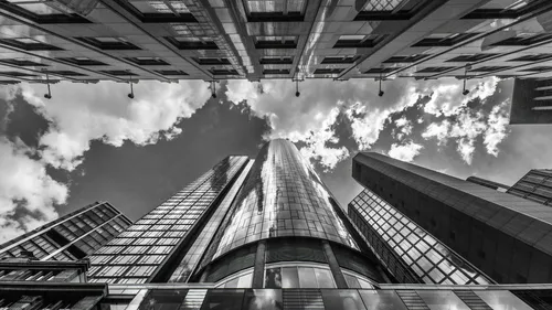 Wolkenkratzer vor bewölktem Himmel von unten betrachtet.