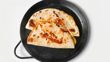 Zwei Quesadillas auf einer schwarzen Pfanne.