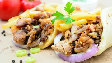 Zwei Gyros-Wraps mit Fleisch, Pommes frites und Gemüse.