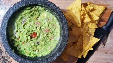Guacamole in Steinschale mit Tortilla-Chips
