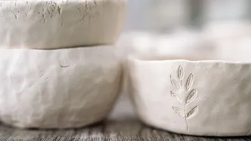 Stacked white ceramic bowls with leaf design.