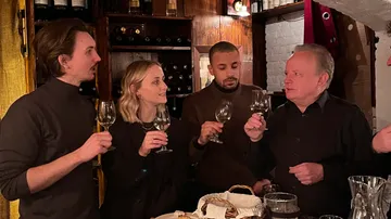 Group tasting wine at a cozy restaurant.