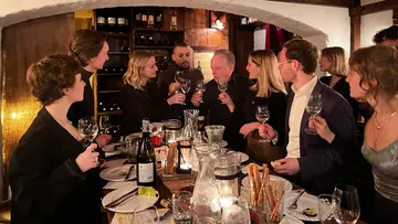 Gruppentoasten mit Weingläsern in einem gemütlichen Restaurant.