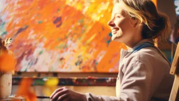 Smiling person painting in colorful studio.