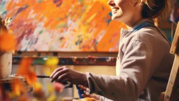 Smiling person painting in colorful studio.
