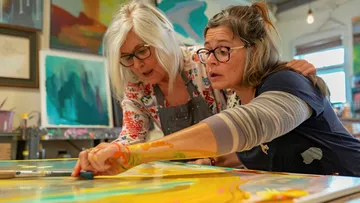 Two women painting in an art studio.