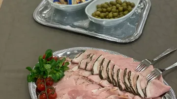 Aufschnitt in Scheiben mit Tomaten und Oliven.