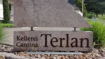 Steinschild mit der Aufschrift 'Kellerei Cantina Terlan' im Freien.