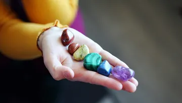 Hand haltend bunte polierte Steine.