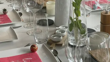 Elegant table setting with glasses, mint, and napkins.