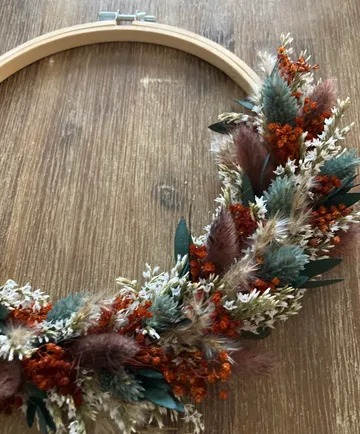 Blumenkranz auf Stickrahmen, Holztisch.