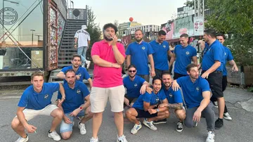 Group of men posing in casual attire outdoors.