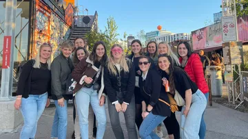 Group of smiling people posing outdoors.