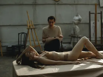 A person lying down is drawn by an artist.