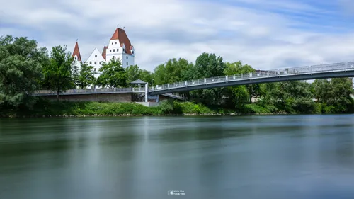 Schloss und Brücke über einen ruhigen Fluss.