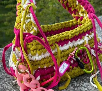 Bunte gehäkelte Handtasche auf Steinoberfläche.