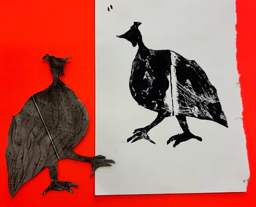 Leaf shaped like bird next to print on paper.