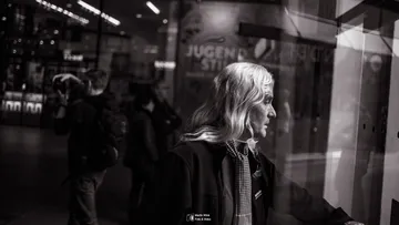 Person with long hair looks at window display.