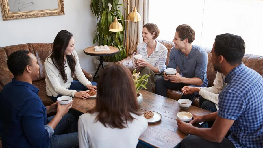 Group of people sitting, talking, and having coffee.