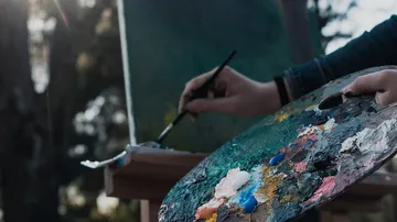 Artist painting with a palette outdoors.