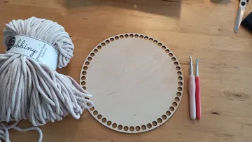 Häkelseil, Holzkreis, Haken auf dem Tisch.