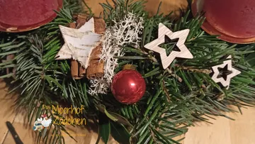 Weihnachtskranz mit Sternen und rotem Ornament.