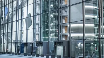 Modern glass building exterior with reflections.