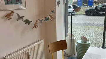 Dinosaurier-Wanddekor, Stuhl, Fenster und Straßenblick.