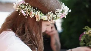 Person wearing floral crown outdoors.