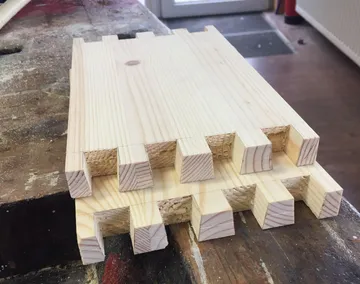 Schwalbenschwanzverbindungen auf Holzbrettern in der Werkstatt.