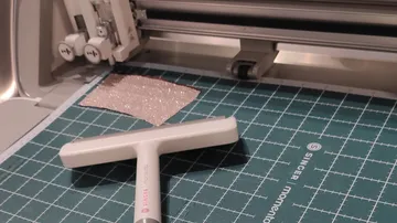 Bastelschneidemaschine mit Schaber und Matte.