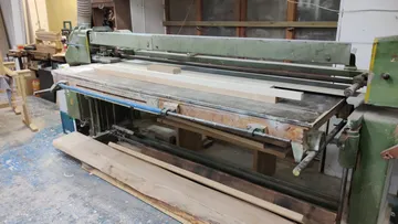 Holzbearbeitungsmaschine mit Brettern in der Werkstatt.