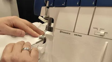 Handbedienende Nähmaschine mit Stoff