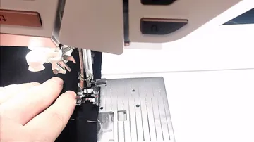 Sewing machine stitching black fabric