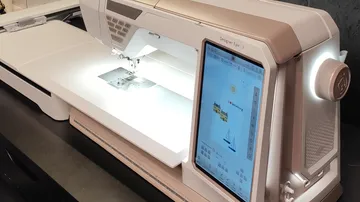 Sewing machine with digital display on table.